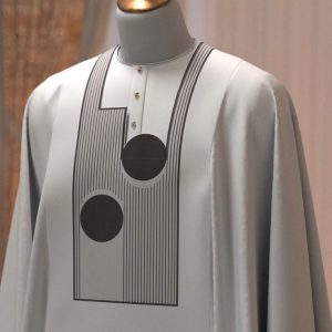 A crisp white Agbada featuring bold, black linear graphics and circular motifs.