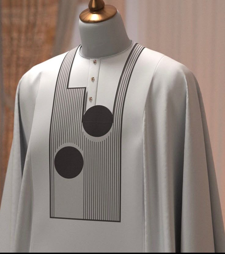 A crisp white Agbada featuring bold, black linear graphics and circular motifs.