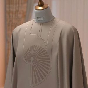 A sophisticated taupe Agbada with a unique spiral-fan embroidery concept.